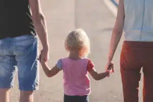 Due genitori tenogno per mano la figlia