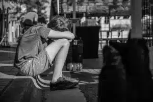 Ragazzo depresso a Padova appoggiato su un marciapiede a Piove di Sacco