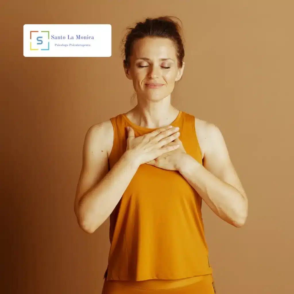 Donna con occhi chiusi e mani sul petto, gesto di calma e ascolto di sé (logo Santo La Monica)