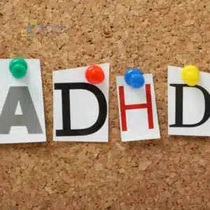 “Lettere ‘ADHD’ su fogli fissati con puntine colorate a una bacheca di sughero.”