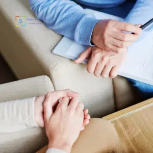Colloquio psicologico con terapeuta che prende appunti durante una seduta.